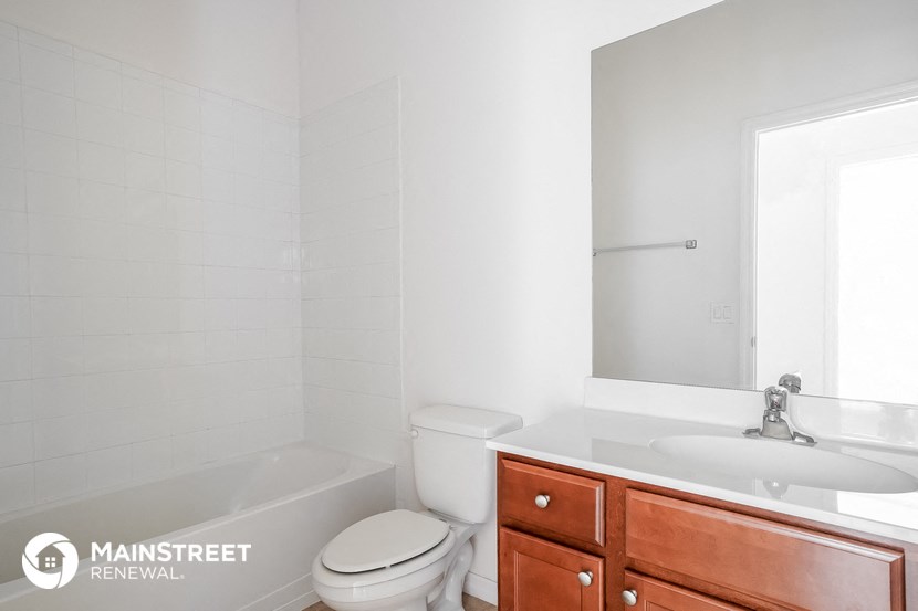 a bathroom with a toilet sink and tub and a mirror
