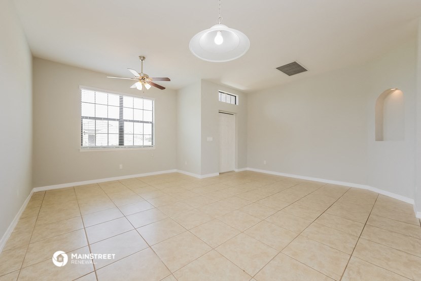 an empty living room with a ceiling fan