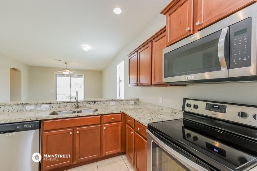 the kitchen has stainless steel appliances and granite counter tops