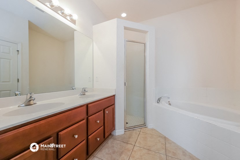 a bathroom with two sinks and a tub and a shower