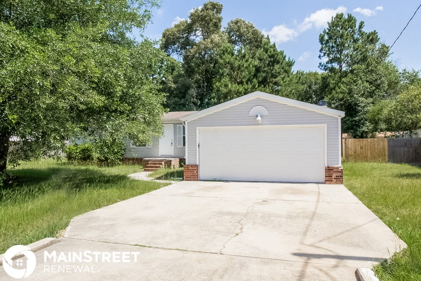 a home with a driveway and a white garage door