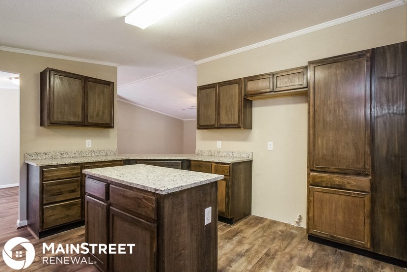a kitchen with wooden cabinets and granite counter tops and a sink
