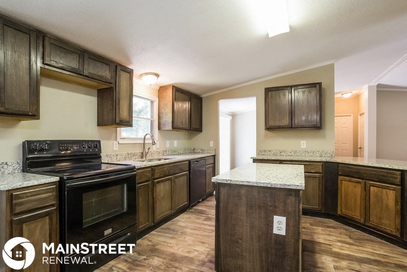 a kitchen with wood cabinets and black appliances and a counter top