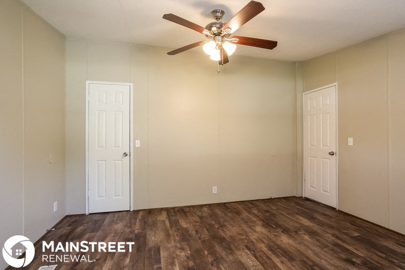 the living room of an apartment with a ceiling fan