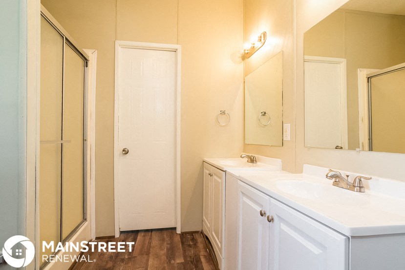 a bathroom with a sink and a shower and a mirror