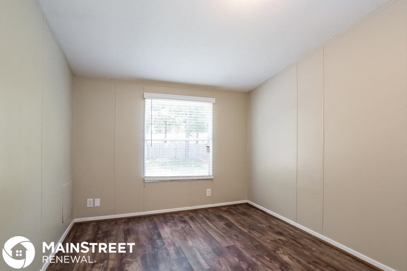 the interior of an empty room with wooden floors and a window