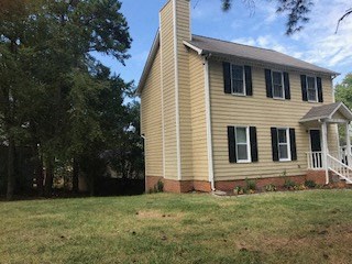 a yellow house with a yard in front of it