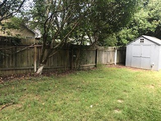 a backyard with a fence and a garage