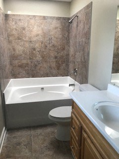 a bathroom with a toilet and a tub and a sink