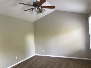 an empty living room with a ceiling fan