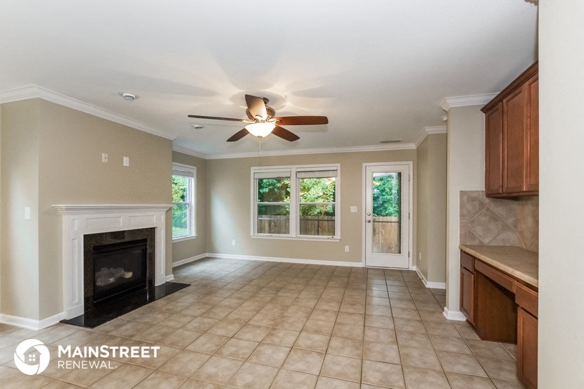 a living room with a fireplace and a ceiling fan