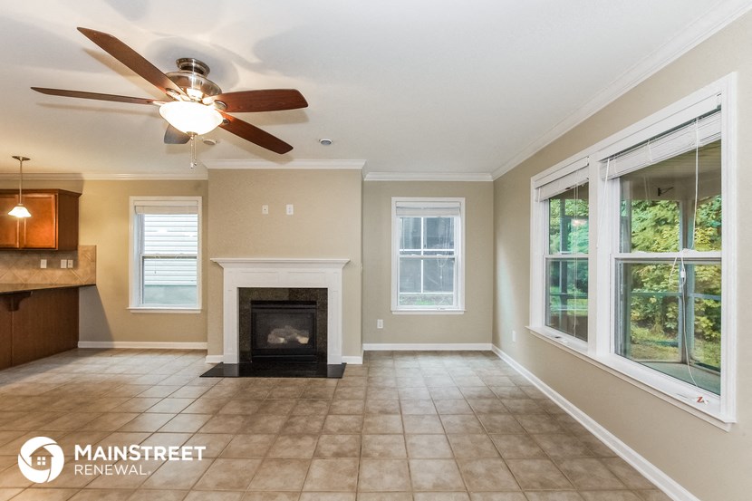 a living room with a fireplace and a ceiling fan