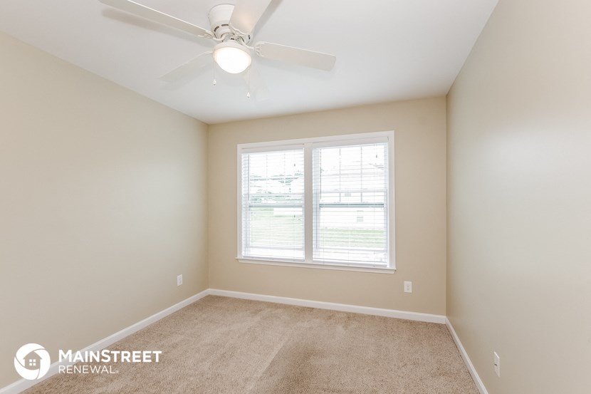 the master bedroom is spacious and has a ceiling fan