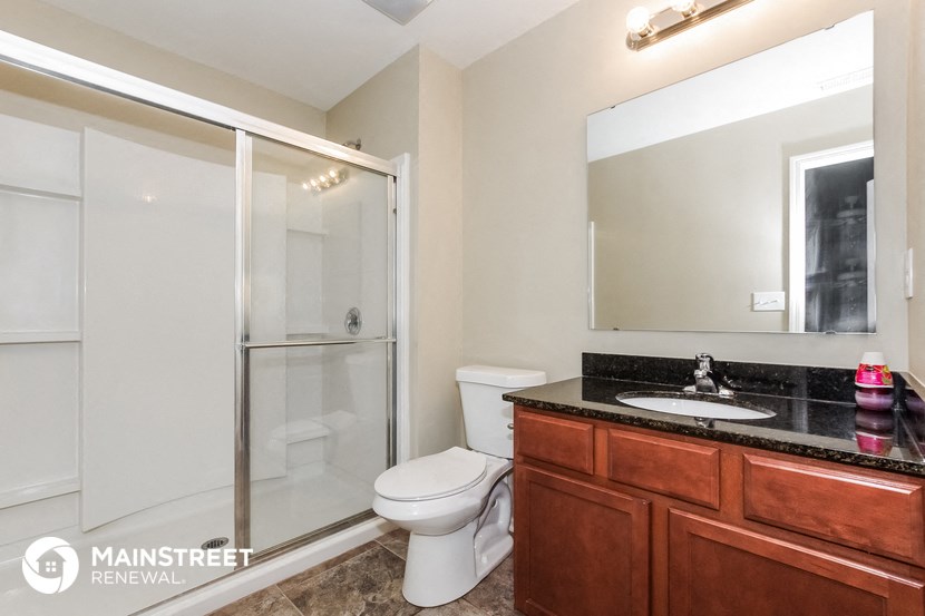 a bathroom with a shower toilet and sink and a mirror