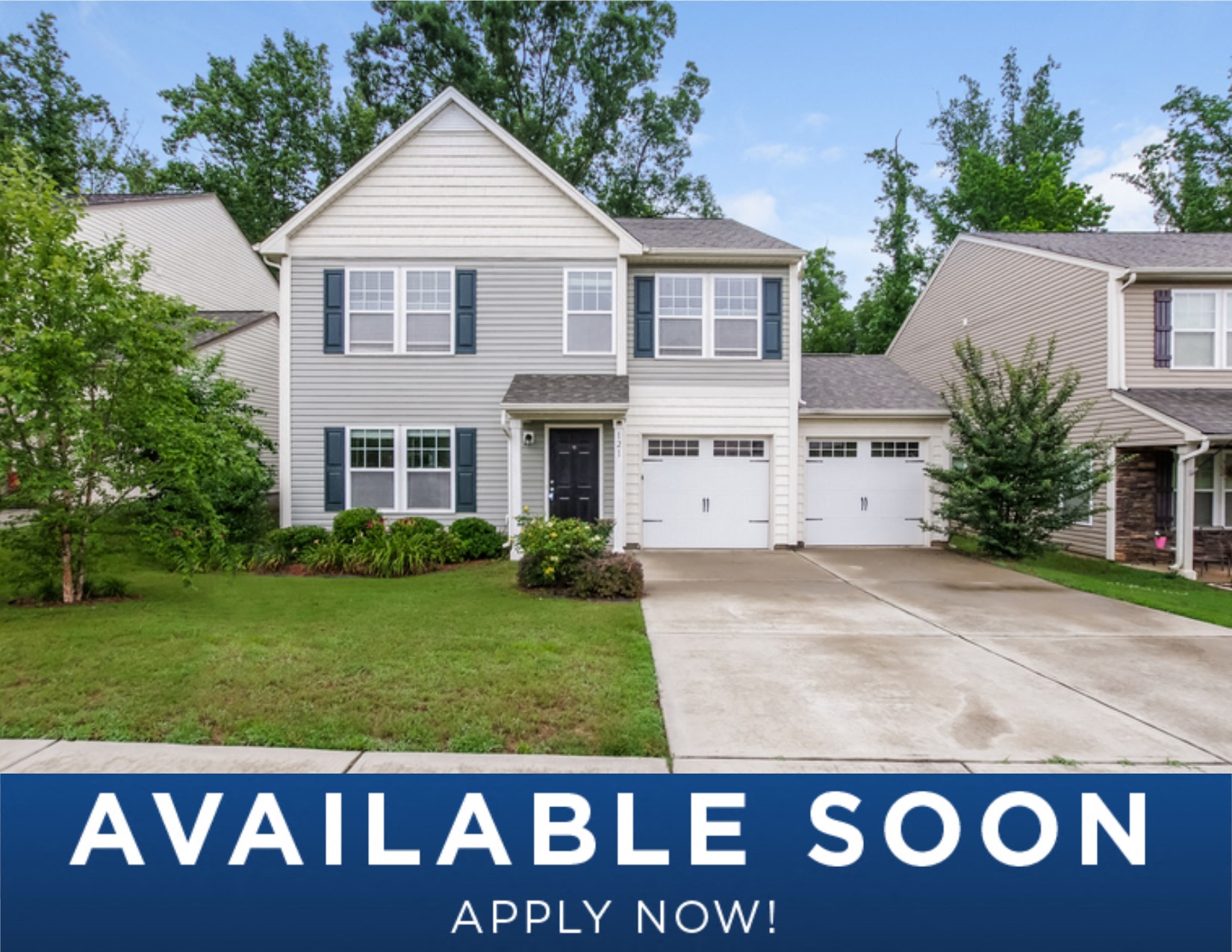 a white house with a driveway and a lawn