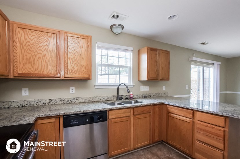 a kitchen with wooden cabinets and granite counter tops and a sink