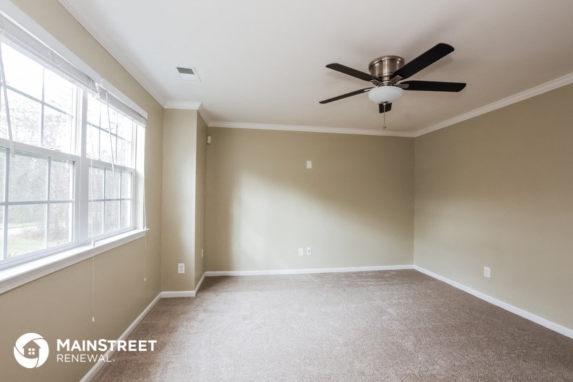an empty room with a ceiling fan and a window