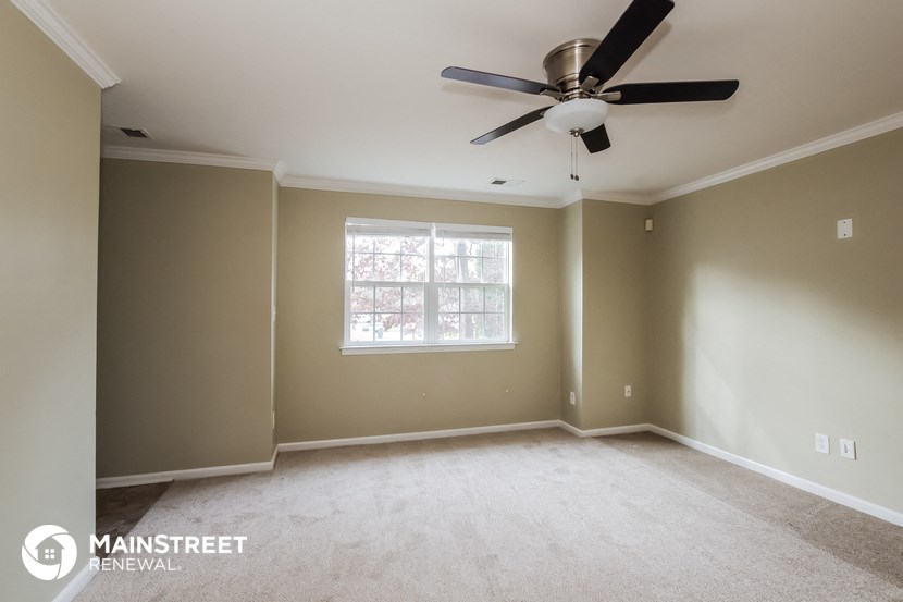 an empty living room with a ceiling fan