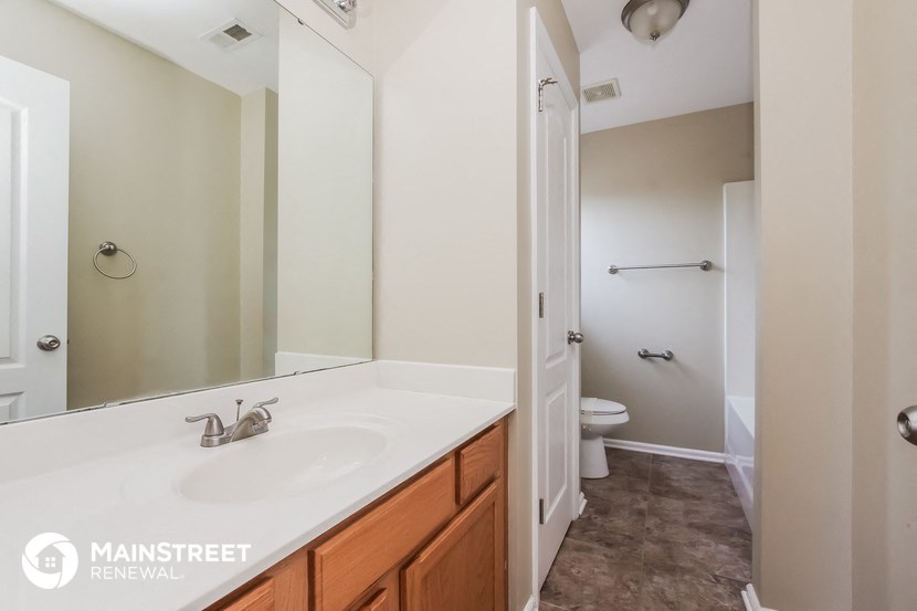 a bathroom with a large mirror and a sink and a toilet