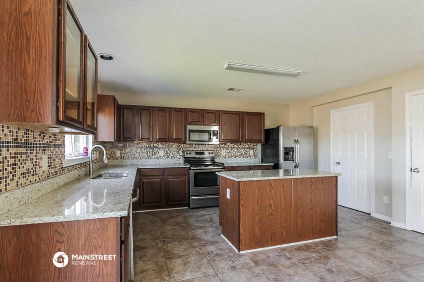 a kitchen with granite counter tops and wooden cabinets