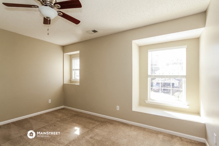 a empty room with a ceiling fan and a window