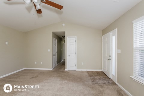a living room with carpet and a ceiling fan