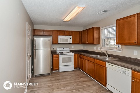 a kitchen with wooden cabinets and stainless steel appliances