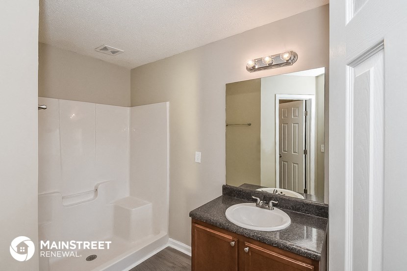 a bathroom with a sink and a mirror and a shower