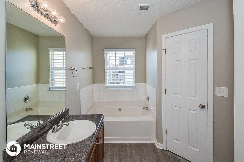 a bathroom with a sink and a tub and a mirror