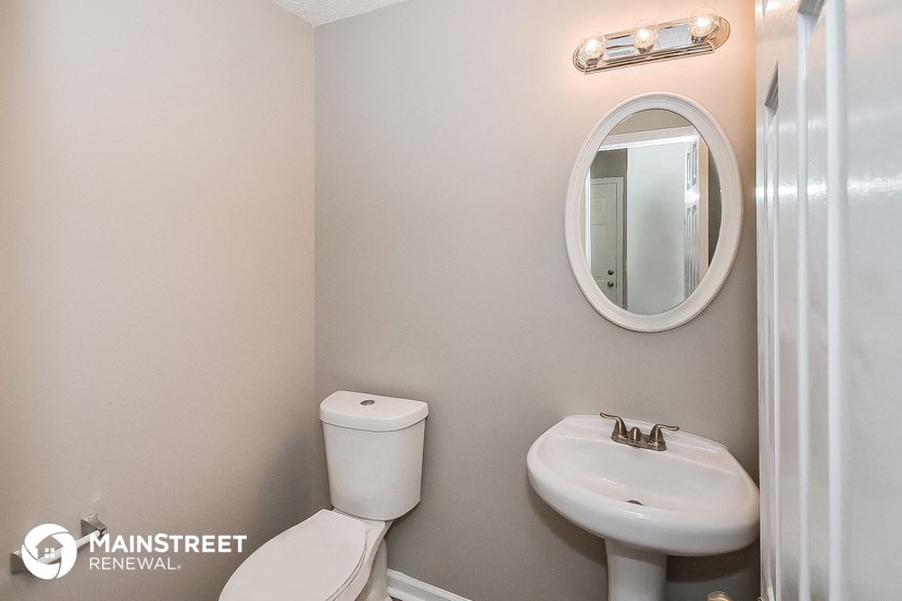 a bathroom with a sink toilet and a mirror