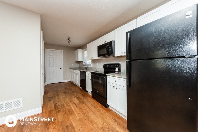 a renovated kitchen with black appliances and white cabinets