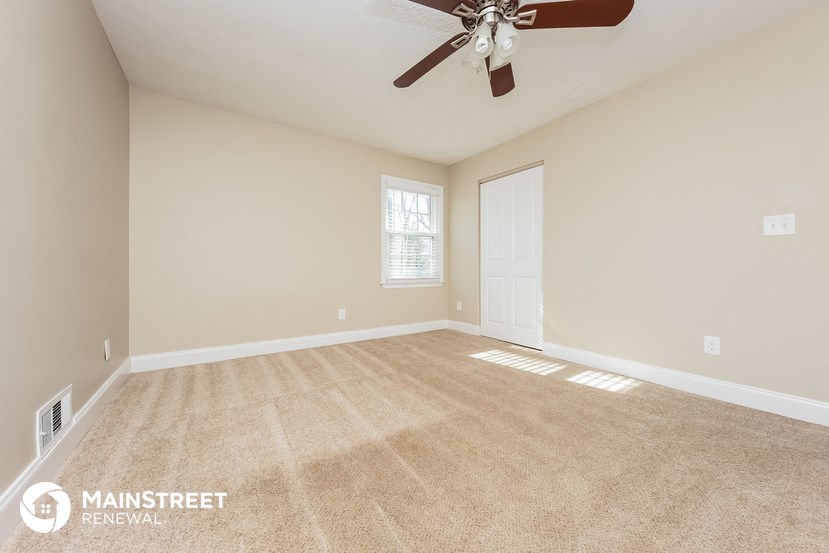 the master bedroom is spacious and clean with a ceiling fan