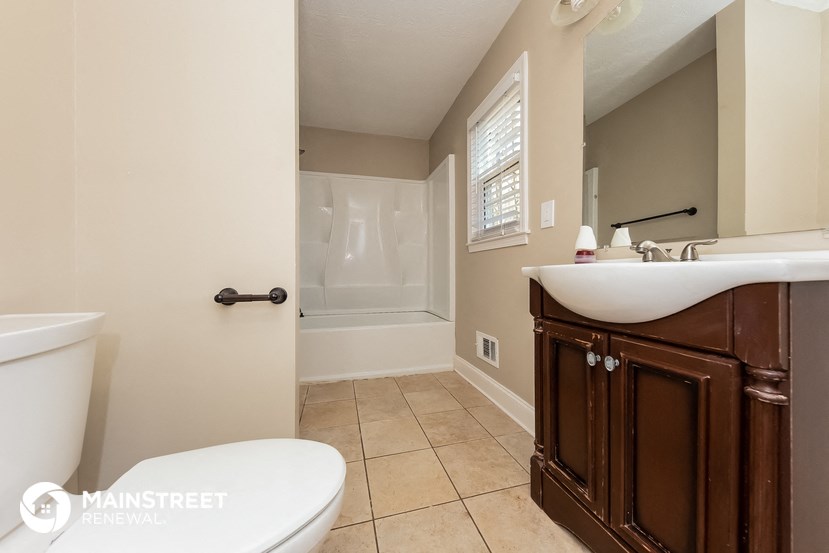 a bathroom with a toilet and a sink and a bath tub
