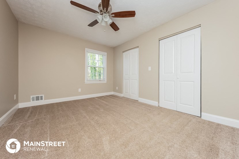 the master bedroom has a carpeted floor and a ceiling fan