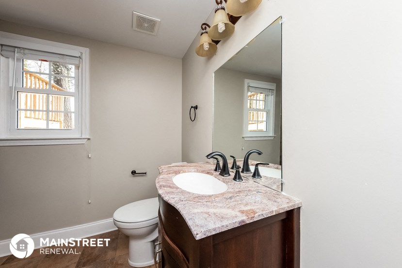a bathroom with a sink and a toilet and a mirror