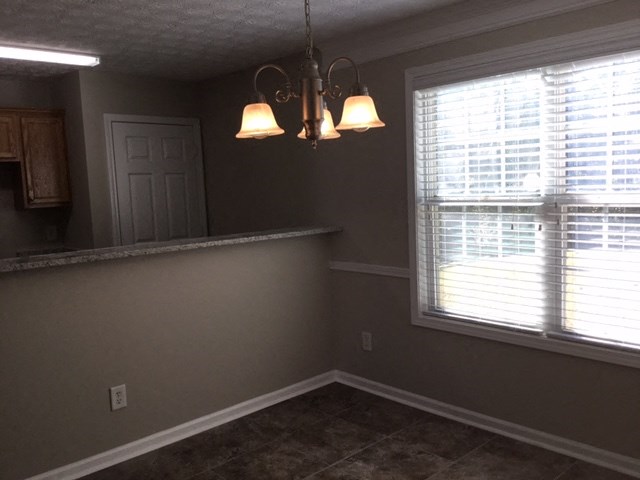 a dining room with a window and a chandelier