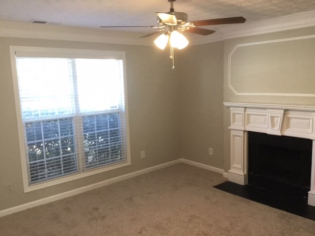 a living room with a fireplace and a ceiling fan