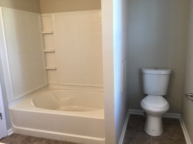 a bathroom with a toilet and a bath tub