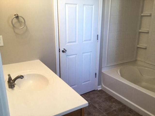 a bathroom with a sink and a tub and a door