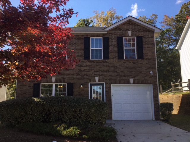 a brown brick house with a white garage door