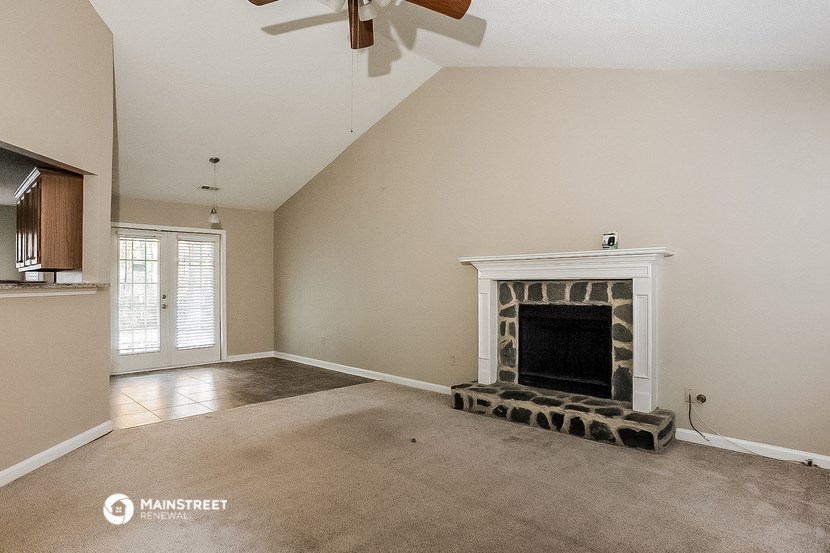 a living room with a fireplace and a ceiling fan