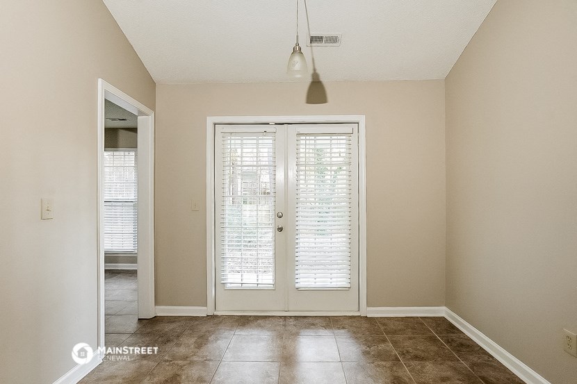 an empty living room with a door to a patio