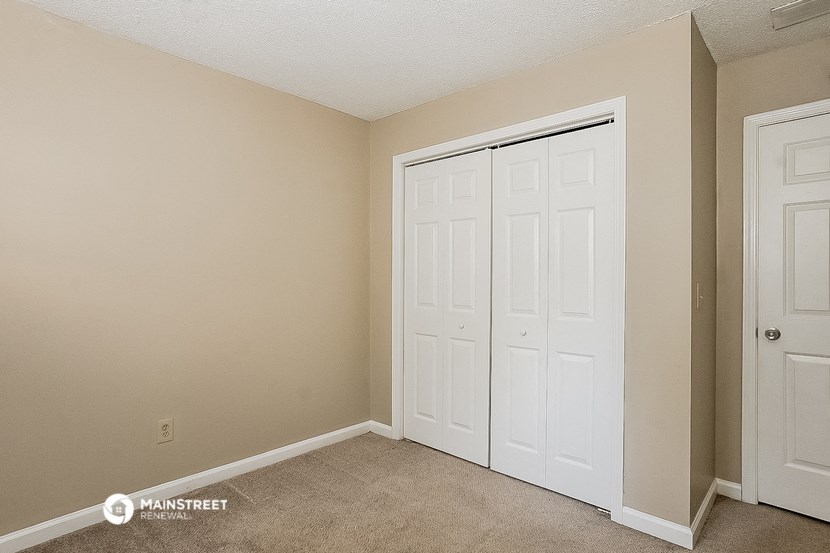 a bedroom with two closets and two doors