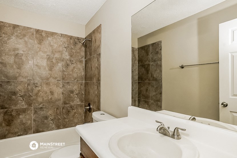 a bathroom with a sink and a shower and a mirror