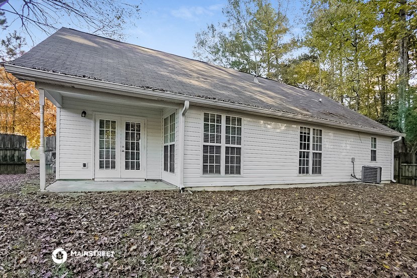 the front of a white house in the woods