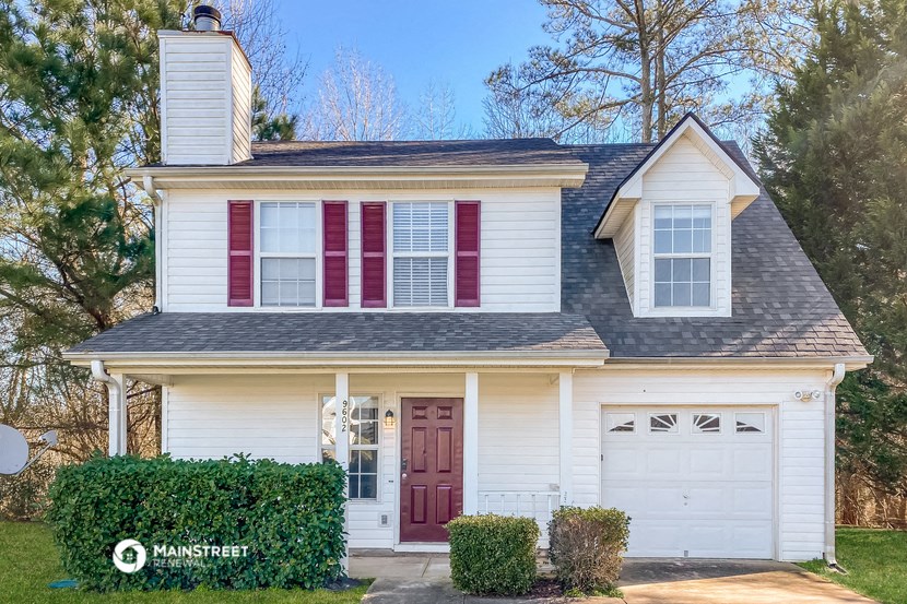 a white house with red shutters and a white garage door