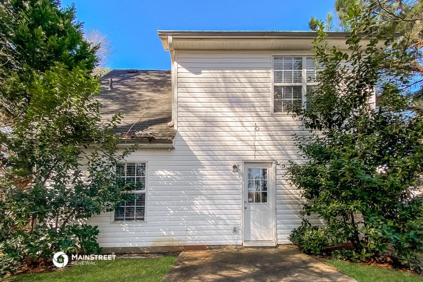 the side of a white house with a white door