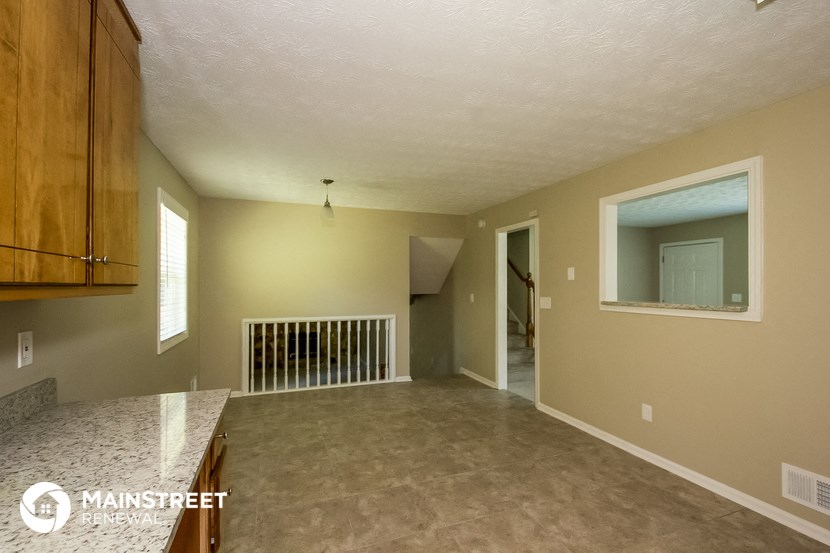 the kitchen and living room of an empty house with a large window