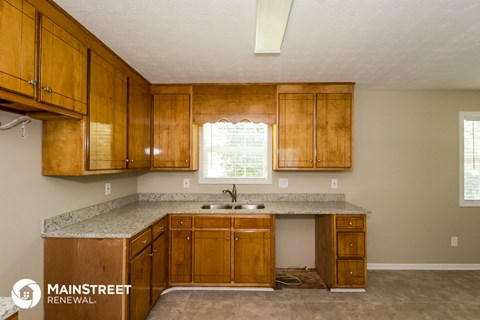 a kitchen with wooden cabinets and granite counter tops and a sink