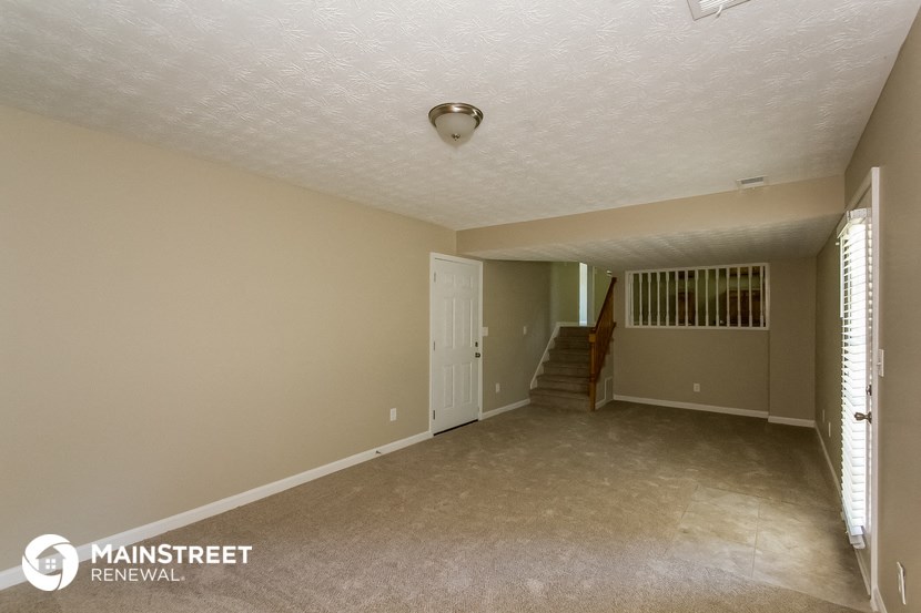 the living room and entryway of an empty house